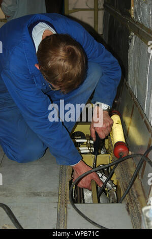 Greymouth, Neuseeland, ca. 2006: Ein Elektriker arbeitet an der Verdrahtung im Erdgeschoss eines Dornier 228 Flugzeugen Stockfoto