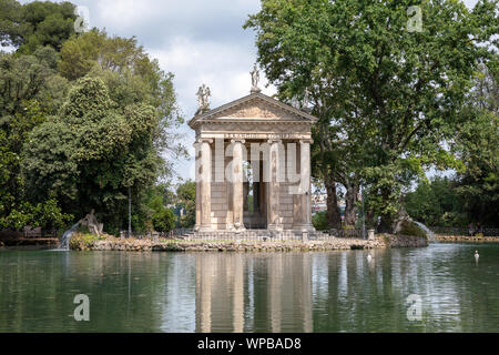 Panoramablick auf den Tempel des Asklepios (Tempio di Esculapio) und See in den öffentlichen Park der Villa Borghese. Tag Sommer und blauer Himmel Stockfoto