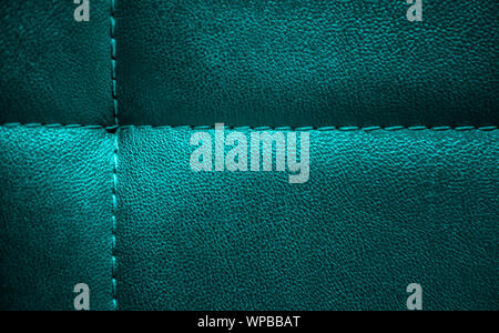 Helle glänzende Türkis künstliche strukturiertes Leder mit der gleichen Farbe Faden genäht. Close-up sofa Oberfläche. Blick von oben. Sehr detaillierte backgro Stockfoto