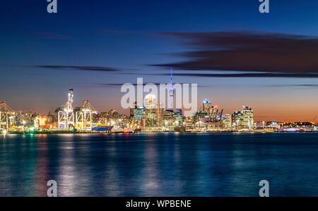 Beleuchtete Skyline von Auckland bei Sonnenuntergang, Waitemata Harbour, Sky Tower, Central Business District, Auckland, Nordinsel, Neuseeland Stockfoto