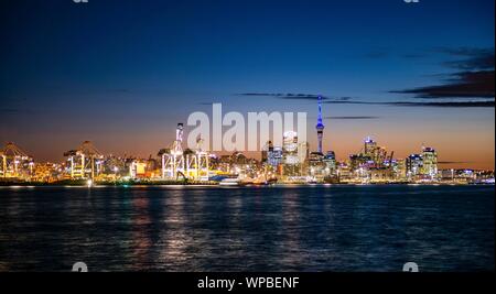 Beleuchtete Skyline von Auckland bei Sonnenuntergang, Waitemata Harbour, Sky Tower, Central Business District, Auckland, Nordinsel, Neuseeland Stockfoto