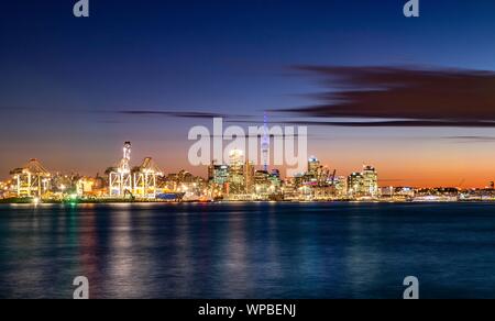 Beleuchtete Skyline von Auckland bei Sonnenuntergang, Waitemata Harbour, Sky Tower, Central Business District, Auckland, Nordinsel, Neuseeland Stockfoto