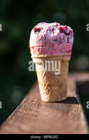 Waffeleis mit Kirschfüllung auf einem Holztisch Auf einem grünen Hintergrund Stockfoto