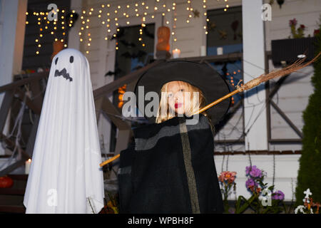 Portrait von niedlichen kleinen mit Besen stand eingerichtete Haus auf Halloween Posing, kopieren Raum Stockfoto