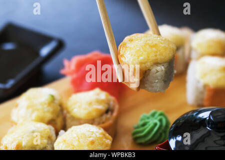 Warme Brötchen mit Ingwer, Wasabi und Lachs auf einem Stand aus Holz. Lecker Japanisch Essen Stockfoto