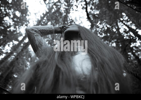 Düstere Stimmung Porträt einer Frau posiert im Wald. Stockfoto