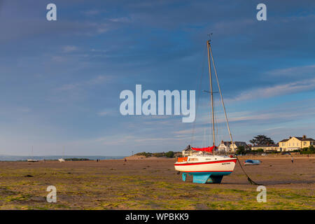 Die Sonne scheint auf einer Yacht bei instow Beach, North Devon mit Menschen in der Ferne genießen den Strand Stockfoto