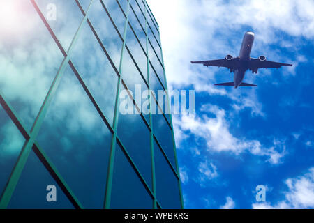 Flugzeug in den Himmel über Wolkenkratzer. Reisen, Urlaub und Business Konzept Stockfoto