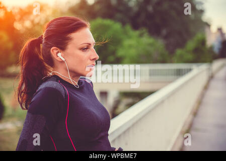 Frau eine Pause vom Training und hören die Musik Stockfoto