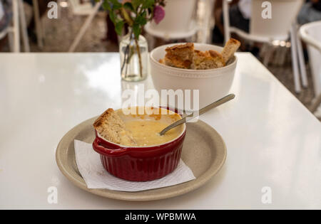 Geschmolzenem Käse und Honig auf weißen Tisch mit Blumen in Lissabon Bar oder Cafe Stockfoto