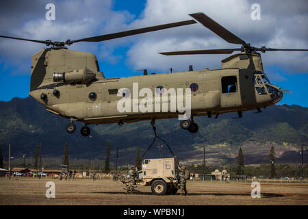 Chief Warrant Officer 3 Gregory Benson, Airdrop Systeme Techniker 25 Sustainment Brigade zugewiesen, 25 Infanterie Division zusammen mit 25 ID HHBN Hauptsitz Wartungspersonal und 25 Combat Aviation Brigade CH-47 Chinook Hubschrauber zu leiten Sling - last Operationen erfolgreich bewegen 3 CONNEXs, einem Anhänger montiert 60 Kw generator, und a4 Tür Humvee aus dem Bereich Röntgen zu Weyland Feld, auf Schofield Barracks, HI zur Unterstützung der Kommandostellenübung. (U.S. Armee Foto von Sgt. Sarah D Sangster) Stockfoto