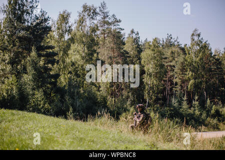 Us-Armee Fallschirmjäger zur 1. Staffel zugewiesen, 91st Cavalry Regiment, 173Rd Airborne Brigade Bildschirme seine Fahrspur für feindliche Bewegung während eines Unternehmens-kombinierte Waffen live-fire Übung in Grafenwöhr Training Area, Deutschland, 23. August 2019. Die 173Rd Airborne Brigade ist der US-Armee Contingency Response Force in Europa, die schnell verlegbaren Truppen nach Europa, Afrika und Zentrale Befehle Verantwortungsbereiche. Vorwärts im Einsatz in Italien und Deutschland, die Brigade routinemäßig Züge neben den NATO-Verbündeten Partnerschaften aufzubauen und das Bündnis zu stärken. Stockfoto