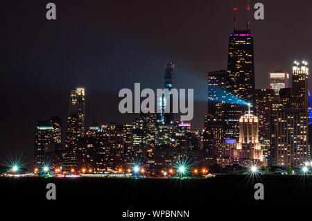Downtown leuchtet in der Nacht. Skyline von Chicago aus dem Norden am Seeufer bei Diversey Hafen. Stockfoto