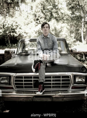 Portrait der junge Mann sitzt auf alten Pickup Truck, kantigen Portrait. Stockfoto