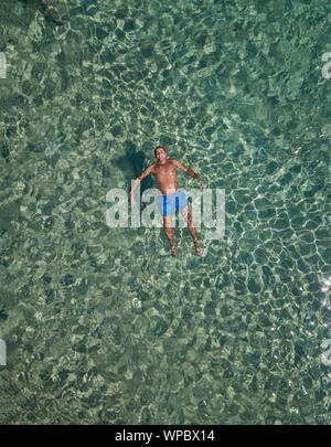 Chubby guy Schwimmen im Meer Antenne Stockfoto