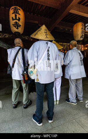 Henro ist das japanische Wort für Pilger - sie erkennbar sind durch ihre weiße Kleidung, segge Hüte und spezielle Stöcke mit Glocken. Die fam Stockfoto