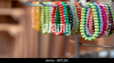 Perlen Armbänder in verschiedenen Farben auf dem Bügel. Es war vor dem Geschäft übernommen. Stockfoto