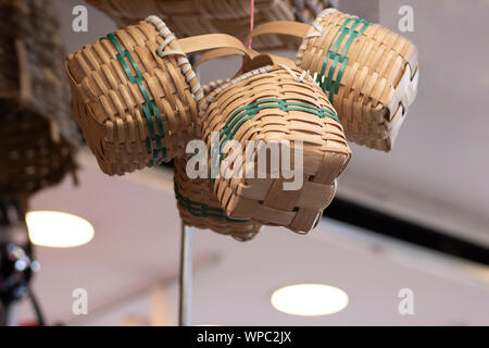 Dekorative Körbe gestrickt. Hängend von oben. Das Foto wurde vor dem Geschäft übernommen. Stockfoto