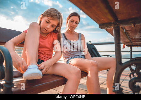 Mutter und Tochter auf der Bank sitzen am Fluss Stockfoto