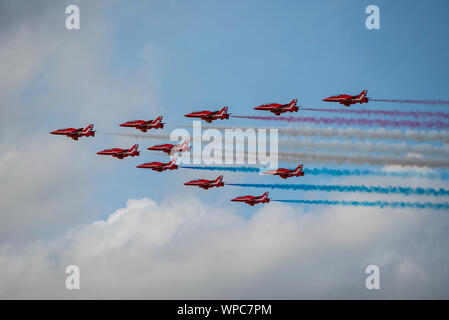 Die RAF Red Arrows display Team Trail roten, weißen und blauen Rauch in der großen Schlacht (plus 2 Flugzeuge) Bildung für RIAT 2019 an RAF Fairford auf 21/07/19. Stockfoto