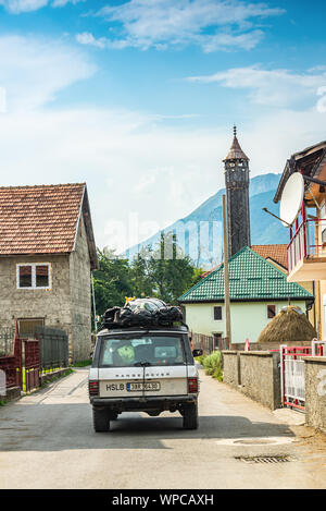 Gusinje, Montenegro - Juli 22., 2019. Touristen in off road Auto durch das Dorf gehen Stockfoto