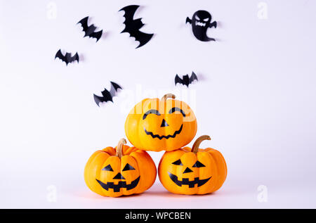 Halloween Konzept. orange Kürbisse und Herde von schwarzem Papier Fledermäuse auf weißem Hintergrund. Stockfoto