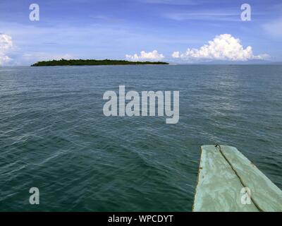 Schöne Aufnahme von einem Boot auf dem Wasser mit einem Insel in der Ferne und ein klarer Himmel Stockfoto