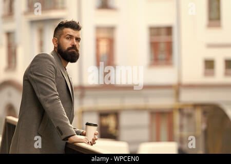 Entspannen und erholen Sie sich. Man bärtige hipster Kaffee trinken Pappbecher. Noch ein Schluck Kaffee. Stadt Lebensstil. Geschäftsmann gepflegt aussehen genießen Sie Kaffee Pause aus Business Center im städtischen Hintergrund. Stockfoto