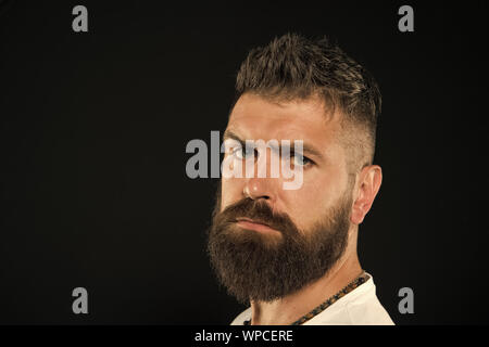 Bringen Sie mehr Stil zu bärtigen Gesicht. Bärtiger Mann auf schwarzem Hintergrund. Ernsthafte bärtigen Hipster mit modischen Haarschnitt. Brutale kaukasischen Kerl trägt Schnurrbart und Bart auf bärtigen Gesicht, kopieren. Stockfoto