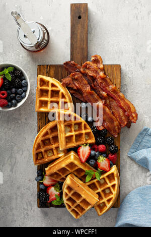 Frühstück mit Waffeln, Beeren und Speck Stockfoto