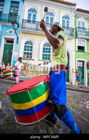 SALVADOR, Brasilien - 15. MÄRZ 2018: ein Schlagzeuger führt mit seinem Vor farbenfrohe Architektur von Pelourinho als Teil eines sozialen Projektes. Stockfoto