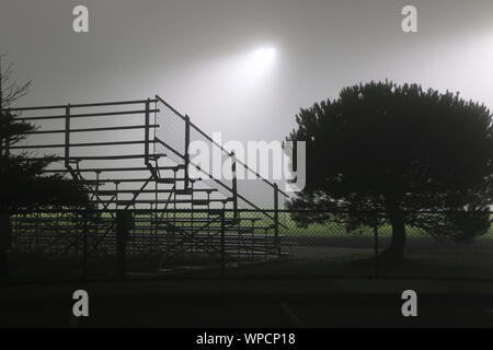 Deserted bleachers under floodlights on a foggy morning, northern California. Stockfoto