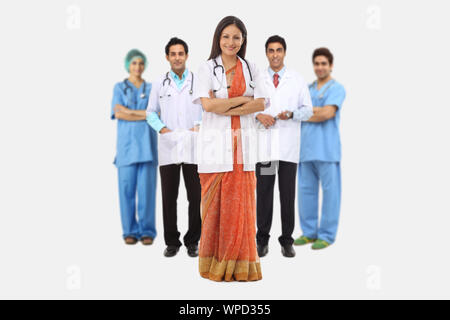 Ärzteteam, geführt von Ärztin, die mit gekreuzten Armen steht Stockfoto
