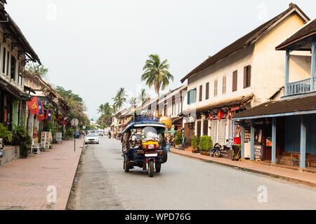 Luang Prabang, Laos - Mai 2019: Tuk-Tuk Motorrad Taxi fahren auf der Straße in den frühen Morgenstunden Stockfoto