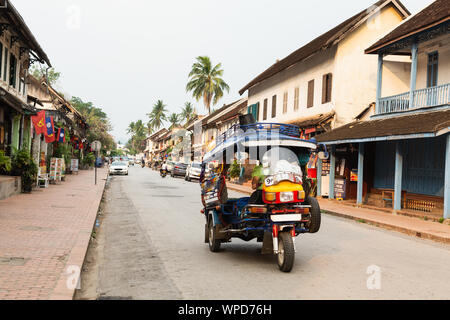 Luang Prabang, Laos - Mai 2019: Tuk-Tuk Motorrad Taxi fahren auf der Straße in den frühen Morgenstunden Stockfoto