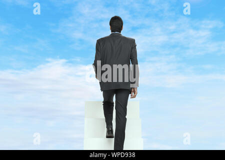 Rückansicht eines Geschäftsmanns, der über die Treppe hinaufgeht Stockfoto