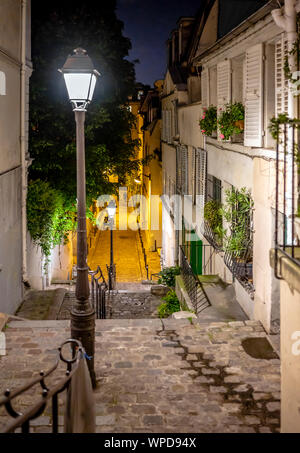 Die Nacht Blick vom Hügel von Montmartre in Paris Street hinunter die Treppe mit der Straßenbeleuchtung in der Mitte gedreht, Menschenmassen anzuziehen Stockfoto