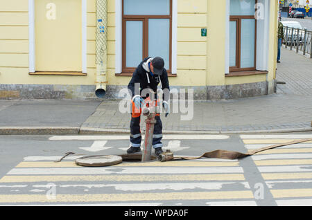 Sankt Petersburg, Russland - Juli 08, 2017: Arbeiter in Overalls installiert ein Hydrant in der Wasserversorgung Stockfoto