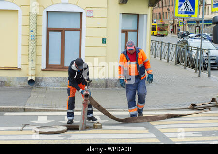 Sankt Petersburg, Russland - Juli 08, 2017: Arbeitnehmer in Overalls installieren Sie ein hydrant und ein Schlauch in die Wasserversorgung befestigen Stockfoto