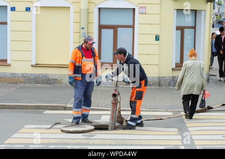 Sankt Petersburg, Russland - Juli 08, 2017: Arbeitnehmer in Overalls installieren Sie ein hydrant und ein Schlauch in die Wasserversorgung befestigen Stockfoto