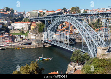 Porto, Portugal. Dom Luis I Brücke über den Fluss Douro und die Verknüpfung von Vila Nova de Gaia, unten, und Porto, oben. Die Boote, die so genannte RABELOS, sobald t Stockfoto