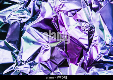 Zerknitterte bunte Folie Hintergrund. Abstrakte Muster mit Schatten. Neon Rosa und blauen Farbtönen. Stockfoto
