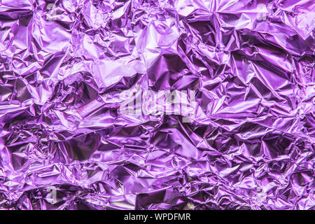 Zerknitterte bunte Folie metallic Hintergrund. Abstrakte Muster mit Schatten. Neon rosa Farbe. Stockfoto
