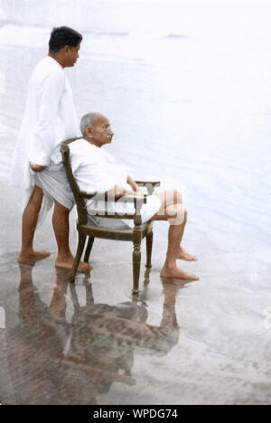 Mahatma Gandhi sitzt auf Stuhl und Devdas Gandhi, Juhu Beach, Bombay, Mumbai, Maharashtra, Indien, Asien, Mai 1944 Stockfoto