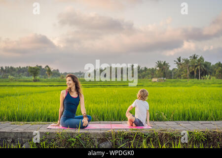 Junge und sein Yoga Lehrer Yoga in einem Reisfeld Stockfoto