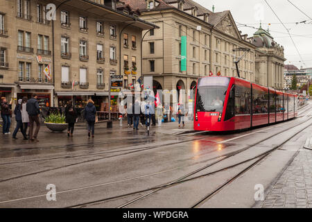 Bern, Schweiz - 7. Mai 2017: Street View von Bern. Red Tram fährt auf der Straße in der Nähe wandern Menschen Stockfoto