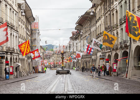 Bern, Schweiz - 7. Mai 2017: Street View der Lebensmittelhändler Gasse. Es ist eine der wichtigsten Straßen in der Altstadt von Bern. Menschen gehen unter bunten Stockfoto