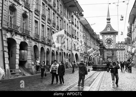 Bern, Schweiz - 7. Mai 2017: Street View der Kramgasse. Es ist eine der wichtigsten Straßen in der Altstadt von Bern. Menschen gehen unter der Flagge von Swis Stockfoto