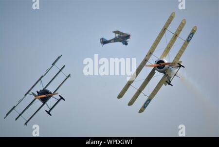 Weltkrieg 1 von Luftfahrzeugen, die in einem Kampf, Fokker sopwith Tri tri Ebene und Ebene. In smokey Skies, Reenactment auf frühen Air Combat. Stockfoto