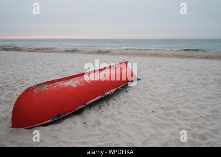 Rettung von orange Rettungsschwimmer Boot umgedreht auf Strand an der Ostseeküste in Białogora, Polen Stockfoto